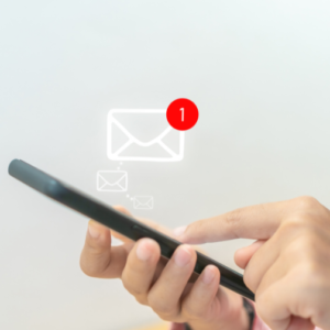 otografija prikazuje roko, ki drži telefon, na zaslonu pa simbol elektronske pošte, simbolizirajoč digitalno komunikacijo