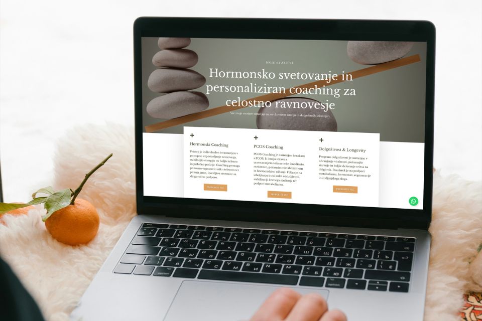 Računalnik s prikazano moderno spletno stranjo in trendi web designa za leto 2026.